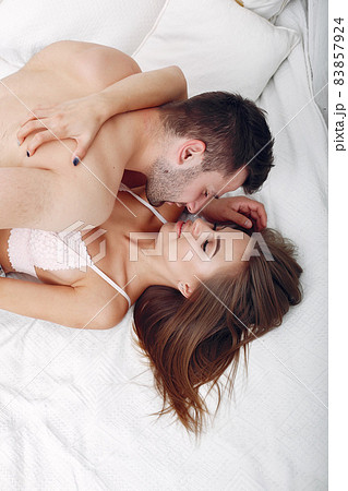 Couple lying on a bed in a room 83857924
