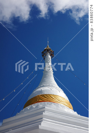 White pagoda wrapped by yellow fabric with blue sky. 83860774
