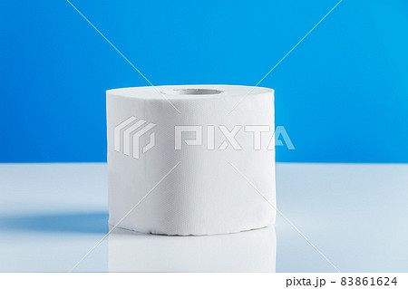 One roll of toilet paper on a blue background. Panic purchase of essential goods. The coronavirus epidemic in the world. One roll of toilet paper on a blue background. Panic purchase of essential goods. The coronavirus epidemic in the world. 83861624
