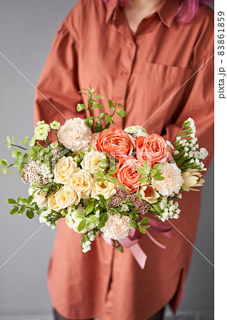 Beautiful bouquet of mixed flowers in woman hand. Floral shop concept . Beautiful fresh cut bouquet. Flowers delivery 83861859