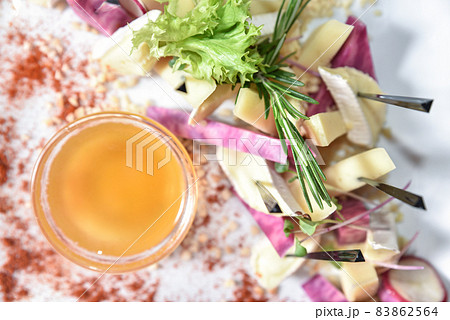 Set of cheese decorated with herbs and honey, top view. Banquet table with delicious food in a restaurant. Professional and exquisite dish serving at restaurant. Catering service 83862564