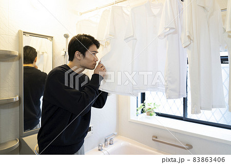 風呂場に干したシャツの匂いを嗅ぐ男性 風呂場に干したシャツの匂いを嗅ぐ男性 83863406