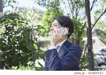 ビジネスマン　電話する　屋外 83864552