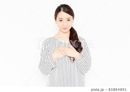 胸に手を当てるカジュアルな服装の女性 83864891