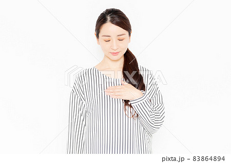 胸に手を当てるカジュアルな服装の女性 胸に手を当てるカジュアルな服装の女性 83864894