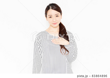 胸に手を当てるカジュアルな服装の女性 83864896