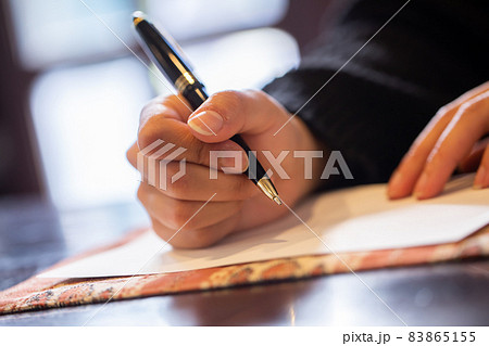 ボールペンで書き物をする男性 83865155