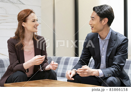 向き合って話をする外国人女性と日本人の男性　グローバルビジネス  英会話スクールイメージ 83866158