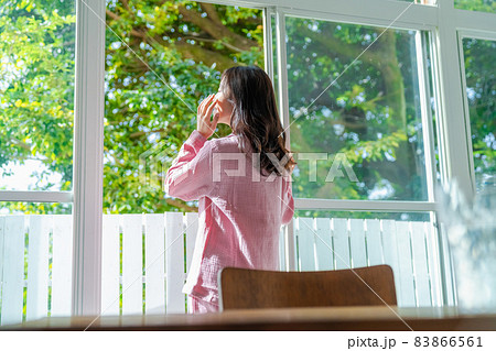 窓際に立って朝の光を浴びる気分爽快な女性 窓際に立って朝の光を浴びる気分爽快な女性 83866561