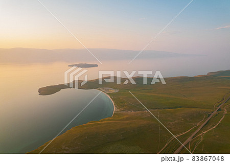 Olkhon Island at sunrise, the largest island in Lake Baikal in eastern Siberia. Shamanka Rock on Baikal lake near Khuzhir at Olkhon island in Siberia, Russia. 83867048
