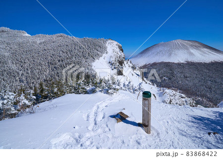 冬の長野県と群馬県の県境にある浅間山を槍ヶ鞘(やりがさや)の道標と共に眺める 83868422