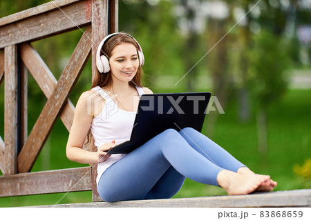 Online learning or teleworking using laptop connected internet via 5g network, young woman does e-learning while visiting public park. 83868659