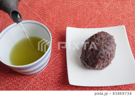 おはぎの横で鉄瓶で緑茶を注ぐ 83869738