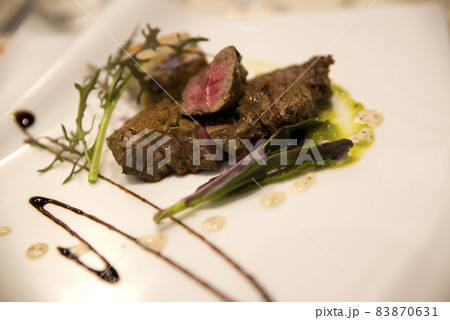 白いお皿の上に神戸牛の肉料理があります の写真素材