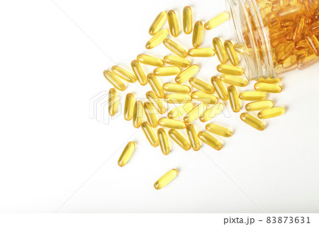 Fish oil in gelatin capsules isolate. Omega vitamins in golden colored pills on a blank white background. Medicine, pharmacy, drugs and multivitamins oils concept Fish oil in gelatin capsules isolate. Omega vitamins in golden colored pills on a blank white background. Medicine, pharmacy, drugs and multivitamins oils concept 83873631