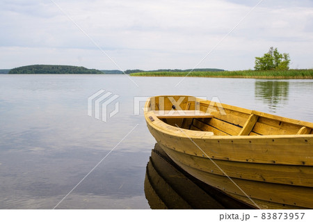 Boat on the lake. Wooden boat on a calm summer lake or river in summer. Zen nature background. 83873957