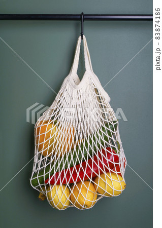 A reusable shopping string bag with vegetables and fruit from the supermarket. Single-use plastic bag ban concept. Zero waste background. High quality photo 83874186