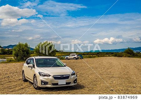 青空の下で河原の砂地に停まっている白い自動車 青空の下で河原の砂地に停まっている白い自動車 83874969