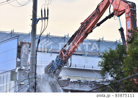 物流倉庫の解体現場　大型重機で取り壊す 83875111