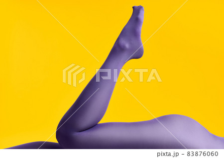 Legs of beautiful young woman in bright tights lying on yellow background 83876060