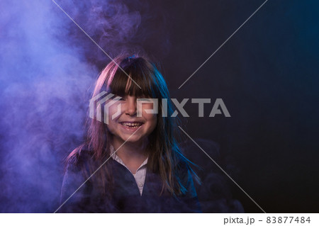 portrait with copy space of a 5-year-old girl having fun with smoke and colored lights portrait with copy space of a 5-year-old girl having fun with smoke and colored lights 83877484