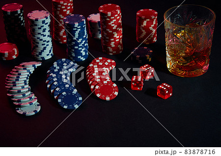 Poker chips and wine glass of cognac on dark table. Gambling 83878716