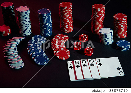 Casino chips and cards on black table surface. Gambling, fortune, game and entertainment concept - close up 83878719