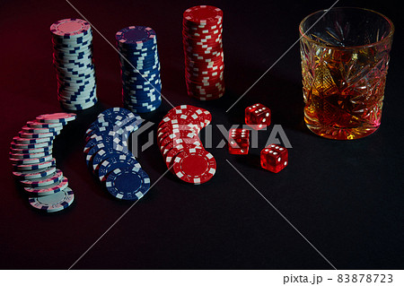 Poker chips and wine glass of cognac on dark table. Gambling 83878723