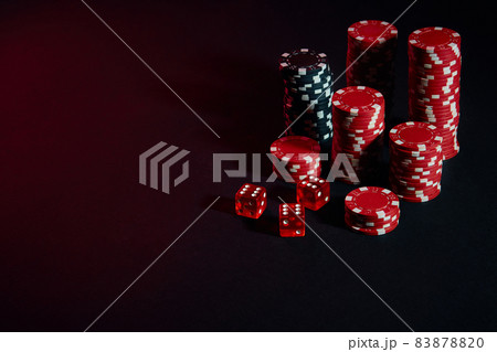 Dice and red and black chips on dark background 83878820
