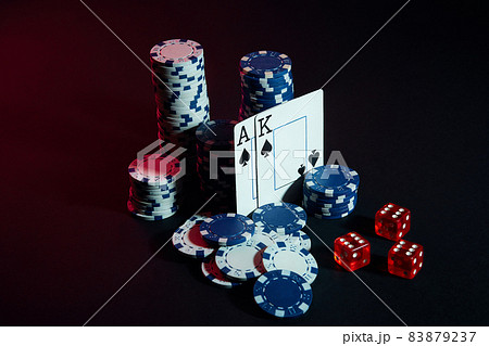 Stack of chips and two cards on dark background - poker game concept 83879237