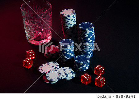 Poker chips and wine glass of cognac on dark table. Gambling 83879241