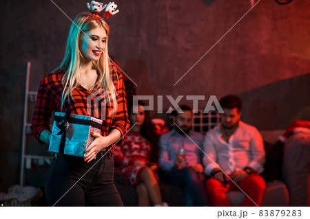 Christmas, x-mas, New year, winter, happiness concept - smiling woman in santa helper hat with gift box Christmas, x-mas, New year, winter, happiness concept - smiling woman in santa helper hat with gift box 83879283