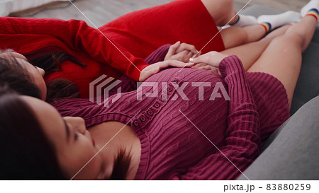 Happy pregnant lesbian couple spending time together at home. Happy pregnant lesbian couple spending time together at home. 83880259