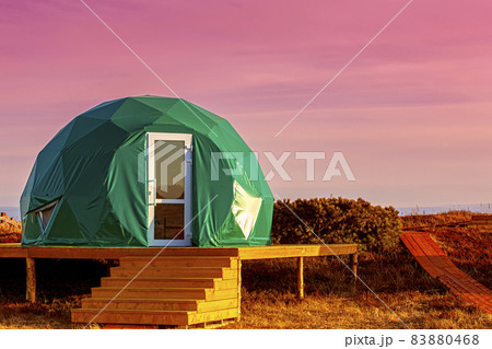 Green glamping on the Pacific Ocean at sunset. Kamchatka Peninsula 83880468