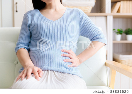 お腹を抑える妊婦　痛い 83881626