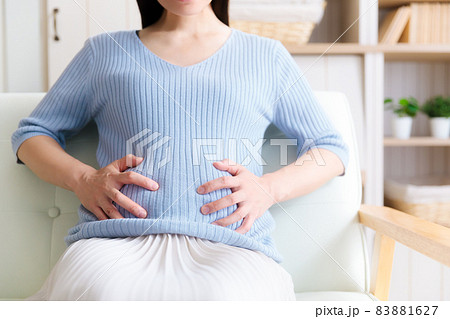 お腹を抑える妊婦　痛い 83881627