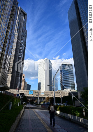 縦位置　新宿高層ビル群　頭上を飛行機が飛ぶ　高層ビルと秋の大空　白い雲が流れる 83882103