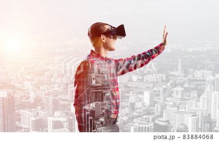 Guy wearing checked shirt and virtual mask stretching hand to touch something 83884068