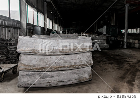 Cast iron tubing reinforced concrete cast products for lining distillation tunnels and underground structures are stored in the warehouse of the industrial plant 83884259