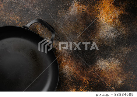 Cast iron frying pan with copy space for text or food with copy space for text or food, top view flat lay , on old dark rustic table background Cast iron frying pan with copy space for text or food with copy space for text or food, top view flat lay , on old dark rustic table background 83884689