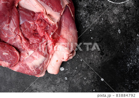 Raw meat products, on black dark stone table background, top view flat lay, with copy space for text 83884792