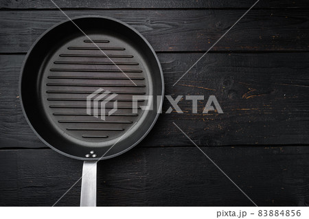 Vintage empty grill pan with copy space for text or food with copy space for text or food, top view flat lay , on black wooden table background 83884856
