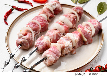 Shish kebab pork meat skewers or shashlik, on white stone table background Shish kebab pork meat skewers or shashlik, on white stone table background 83884858