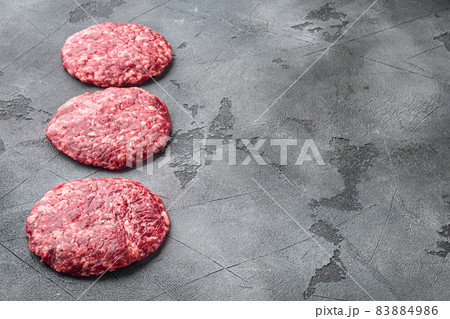 Raw Minced Steak Burgers from Beef Meat, on gray stone background, with copy space for text Raw Minced Steak Burgers from Beef Meat, on gray stone background, with copy space for text 83884986