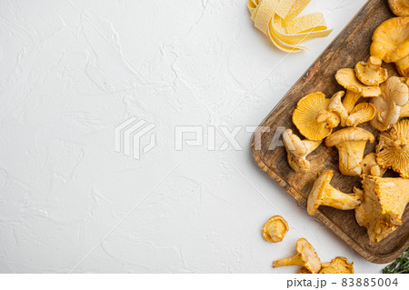 Raw pasta and mushrooms and ingredients, on white stone table background, top view flat lay, with copy space for text 83885004