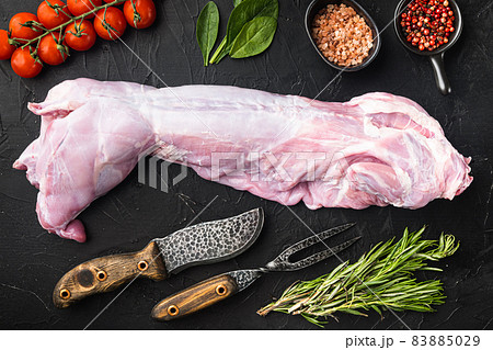 Raw and fresh meat. Whole rabbit ready to cook with ingredients, on black stone background, top view flat lay 83885029