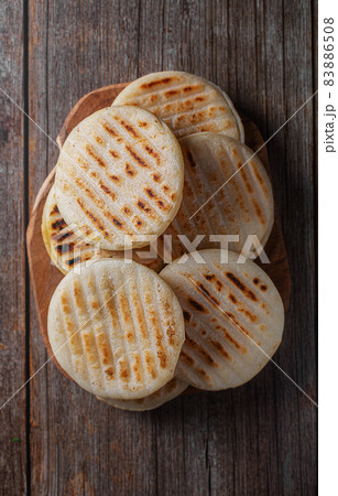 Traditional Venezuelan food arepa made from cornmeal, wooden background 83886508