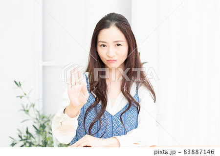 NGのポーズをするリビングで椅子に座っている主婦 83887146