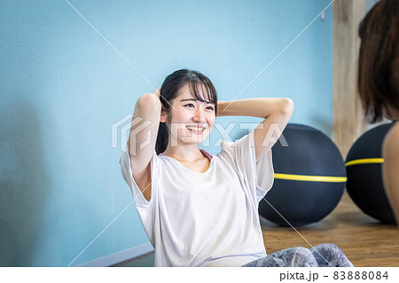 パーソナルトレーナーと腹筋をする女性(女性) パーソナルトレーナーと腹筋をする女性(女性) 83888084