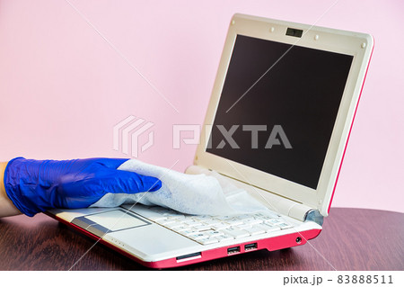 Disinfection and cleaning of the laptop and home surfaces. The concept of preventive protection against coronavirus. Health care during a pandemic. 83888511